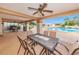 Covered patio with outdoor dining, ceiling fan, and views of the swimming pool and community landscaping at 3835 Sailmaker Ln # X, Holiday, FL 34691