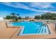 Sparkling blue community pool with sun loungers and a secure fence, perfect for relaxation and recreation at 3835 Sailmaker Ln # X, Holiday, FL 34691