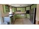 Kitchen area featuring sleek stainless steel appliances, green cabinets and granite countertops at 3925 W Eden Roc Cir, Tampa, FL 33634