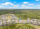 An aerial view of the neighborhood homes surrounded by lush forest with water features nearby at 4166 Epic Cv, Land O Lakes, FL 34638