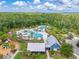 Aerial view of community amenities, including a playground, pool, and clubhouse surrounded by lush landscaping at 4166 Epic Cv, Land O Lakes, FL 34638