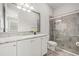Bright bathroom featuring granite counters, white cabinets, large mirror and a glass shower at 4166 Epic Cv, Land O Lakes, FL 34638
