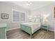 Cozy bedroom with plantation shutters, wood-look flooring, and decorative accents at 4166 Epic Cv, Land O Lakes, FL 34638