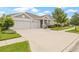 Inviting one-story home with a spacious three-car garage and a beautifully landscaped front yard, showcasing curb appeal at 4166 Epic Cv, Land O Lakes, FL 34638