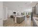 Open-concept kitchen with stainless steel appliances, a large island, and a seamless flow into the living area at 4166 Epic Cv, Land O Lakes, FL 34638