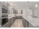 Gourmet kitchen featuring gray cabinets, stainless steel appliances, granite counters, and a wine cooler at 4166 Epic Cv, Land O Lakes, FL 34638
