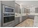 Elegant kitchen equipped with stainless steel appliances, wine cooler, and stylish gray cabinetry at 4166 Epic Cv, Land O Lakes, FL 34638