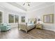 Bright main bedroom with tray ceiling, natural light, wood-look floors, and neutral decor at 4166 Epic Cv, Land O Lakes, FL 34638