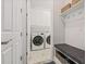 Mud room with bench, hooks, shelving, and a view into the laundry room with modern appliances at 4166 Epic Cv, Land O Lakes, FL 34638