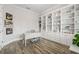 Home office with white built-in shelves and drawers, hardwood floor and an elegant writing desk at 4166 Epic Cv, Land O Lakes, FL 34638