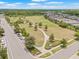 Aerial view of the community park with mature trees and sidewalks near a parking lot with neighborhood homes nearby at 4166 Epic Cv, Land O Lakes, FL 34638
