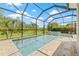 A screened-in pool with a connected spa is surrounded by a brick patio at 4166 Epic Cv, Land O Lakes, FL 34638