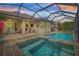 This screened-in pool features a connected spa and an outdoor seating area at sunset at 4166 Epic Cv, Land O Lakes, FL 34638