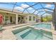 This screened-in pool features a connected spa and an outdoor seating area at 4166 Epic Cv, Land O Lakes, FL 34638