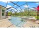 Screened-in pool with spa and travertine deck with a view of the backyard at 4166 Epic Cv, Land O Lakes, FL 34638