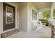 Charming front porch with decorative glass door, rocking chairs, and stone accents offers a welcoming outdoor space at 4166 Epic Cv, Land O Lakes, FL 34638