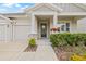 Inviting front porch with stone accents, colorful flower baskets, and well-maintained landscaping creating a warm welcome at 4166 Epic Cv, Land O Lakes, FL 34638