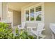 Cozy front porch featuring white rocking chairs, a small table, and lush greenery for a relaxing outdoor space at 4166 Epic Cv, Land O Lakes, FL 34638