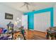Bright bedroom with colorful accent wall, ceiling fan, and hardwood floors at 5001 Queen Palm Ne Ter, St Petersburg, FL 33703