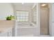 Bright bathroom features a garden tub, shower, and decorative glass block window detail at 5001 Queen Palm Ne Ter, St Petersburg, FL 33703