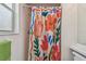Bright bathroom featuring a shower with a colorful floral-themed curtain and white tiled walls at 5001 Queen Palm Ne Ter, St Petersburg, FL 33703