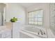 Bright bathroom features a garden tub, window with blinds, and plant on the counter at 5001 Queen Palm Ne Ter, St Petersburg, FL 33703