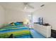 Bedroom featuring a ceiling fan, a window, and a dresser with a TV at 5001 Queen Palm Ne Ter, St Petersburg, FL 33703