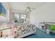 Spacious bedroom with blue carpet, ceiling fan, and sliding glass doors providing natural light at 5001 Queen Palm Ne Ter, St Petersburg, FL 33703