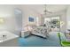 Sunlit bedroom with blue carpet, a ceiling fan, and sliding doors leading to the outdoor pool area at 5001 Queen Palm Ne Ter, St Petersburg, FL 33703