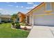 Charming single-Gathering home featuring a well-manicured lawn, beautiful landscaping, and a terracotta-tiled roof at 5001 Queen Palm Ne Ter, St Petersburg, FL 33703