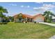 Charming single-Gathering home featuring a well-manicured lawn, beautiful landscaping, and a terracotta-tiled roof at 5001 Queen Palm Ne Ter, St Petersburg, FL 33703
