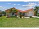Charming single-Gathering home featuring a well-manicured lawn, beautiful landscaping, and a terracotta-tiled roof at 5001 Queen Palm Ne Ter, St Petersburg, FL 33703