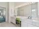 Bright, spacious main bathroom with double sinks, vanity lighting, and a green chair at 5001 Queen Palm Ne Ter, St Petersburg, FL 33703