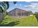 Spacious backyard featuring a screened pool, brick patio, and lush greenery, creating an inviting outdoor retreat at 5001 Queen Palm Ne Ter, St Petersburg, FL 33703