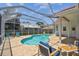 Serene screened-in pool area boasting a brick patio, clear blue water, and ample seating for outdoor enjoyment at 5001 Queen Palm Ne Ter, St Petersburg, FL 33703