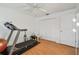 Well-lit spare room features laminated wood flooring, white walls, a ceiling fan, and a treadmill at 5001 Queen Palm Ne Ter, St Petersburg, FL 33703