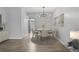 View of dining area, featuring modern chandelier, neutral finishes, wood-look floors, and bright natural light at 5095 Bay Ne St # 210, St Petersburg, FL 33703