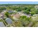 Aerial shot of a single-Gathering home surrounded by trees and other homes in a residential neighborhood at 534 Berkley Ave, Tarpon Springs, FL 34689