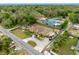 Charming yellow house featuring a circular driveway and lush green surroundings from an aerial perspective at 534 Berkley Ave, Tarpon Springs, FL 34689