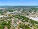 A high aerial view showcases the location of a single-Gathering home nestled amidst a lush neighborhood with a commercial center nearby at 534 Berkley Ave, Tarpon Springs, FL 34689
