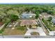 Overhead shot of the property highlighting its expansive yard, circular driveway, and proximity to surrounding trees at 534 Berkley Ave, Tarpon Springs, FL 34689
