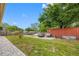 Expansive backyard featuring lush greenery, a patio, and a storage container, ideal for outdoor activities at 534 Berkley Ave, Tarpon Springs, FL 34689