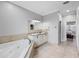 Bright bathroom featuring a soaking tub, double vanity, and tile flooring at 534 Berkley Ave, Tarpon Springs, FL 34689