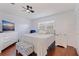 Cozy bedroom features wood floors, large window, ceiling fan and is furnished with a dresser and queen bed at 5603 80Th N St # 107, St Petersburg, FL 33709