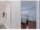 Hallway view into a bedroom with wood floors and ensuite bathroom featuring a tiled shower at 5603 80Th N St # 107, St Petersburg, FL 33709