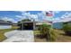 Charming single-story home featuring a carport, mature landscaping, and an American flag waving proudly at 5647 Arrowhead Dr, Zephyrhills, FL 33542