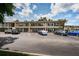 Beige condominium complex with ample parking and well-maintained landscaping on a sunny day at 5694 40Th N Ter # 423, Kenneth City, FL 33709