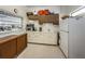 A clean kitchen featuring white cabinets, essential appliances, and a convenient pass-through window at 5694 40Th N Ter # 423, Kenneth City, FL 33709