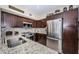 Kitchen featuring stainless steel appliances, granite countertops, mosaic tile backsplash and dark wood cabinetry at 5694 40Th N Ter # 423, Kenneth City, FL 33709