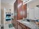 Bathroom featuring dark wood cabinets, granite countertops, decorative mirror, and shower at 5724 Shell Ridge Dr, Lithia, FL 33547